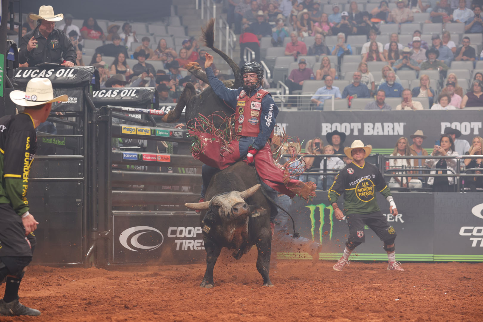 Arena crew surrounding a bull rider during a professional competition